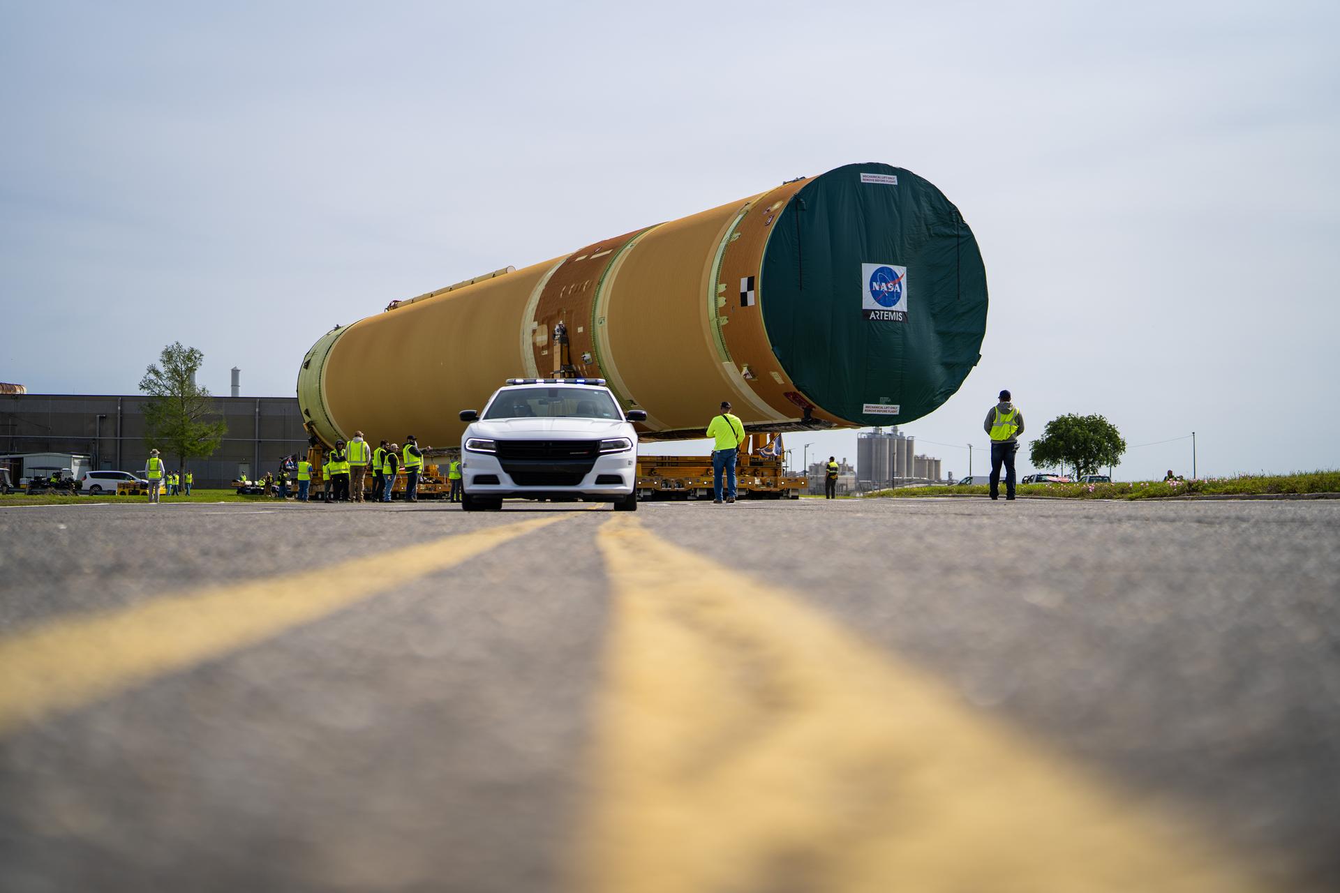 NASA moved the core stage, or the largest section, of the SLS (Space Launch System) rocket that will launch the crewed Artemis III mission in 2027 from the agency’s Michoud Assembly Facility to the agency’s Pegasus barge in New Orleans on April 20. The barge will ferry the top four-fifths – the section containing the liquid hydrogen tank, liquid oxygen tank, intertank, and forward skirt – of the SLS core stage to NASA’s Kennedy Space Center in Florida to complete outfitting and vertical integration.  Teams with NASA and Boeing, the SLS core stage lead contractor, used specialized transporters to guide the top four-fifths from the NASA rocket factory to Pegasus. Prior to the move, technicians added an engine section transportation simulator to the rocket stage for shipment to the Space Coast.  Next year’s Artemis III mission will launch astronauts to Earth’s orbit aboard the Orion spacecraft on top of SLS to test rendezvous and docking capabilities between Orion and commercial spacecraft needed to land Artemis IV astronauts on the Moon in 2028. NASA’s SLS is the only rocket capable of sending Orion, astronauts, and supplies to the Moon in a single launch.
